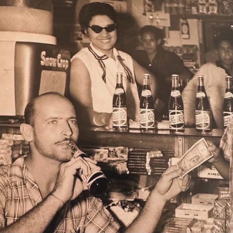 Sepia archival photograph showing people and drinks at a soda-fountain counter